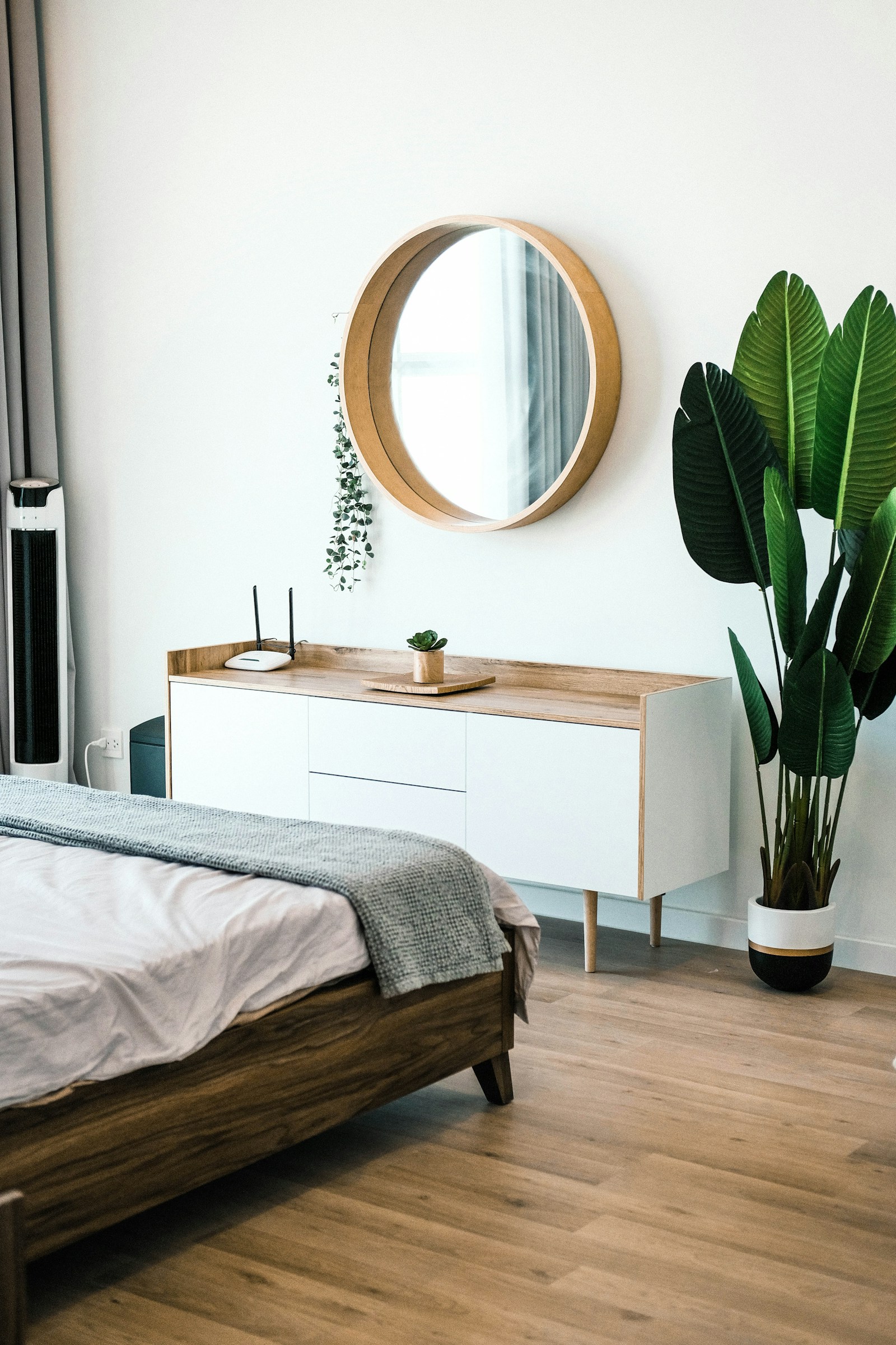 Illustrative reference photograph of a white dresser with a round mirror in a bedroom; not NicLogistics inventory.