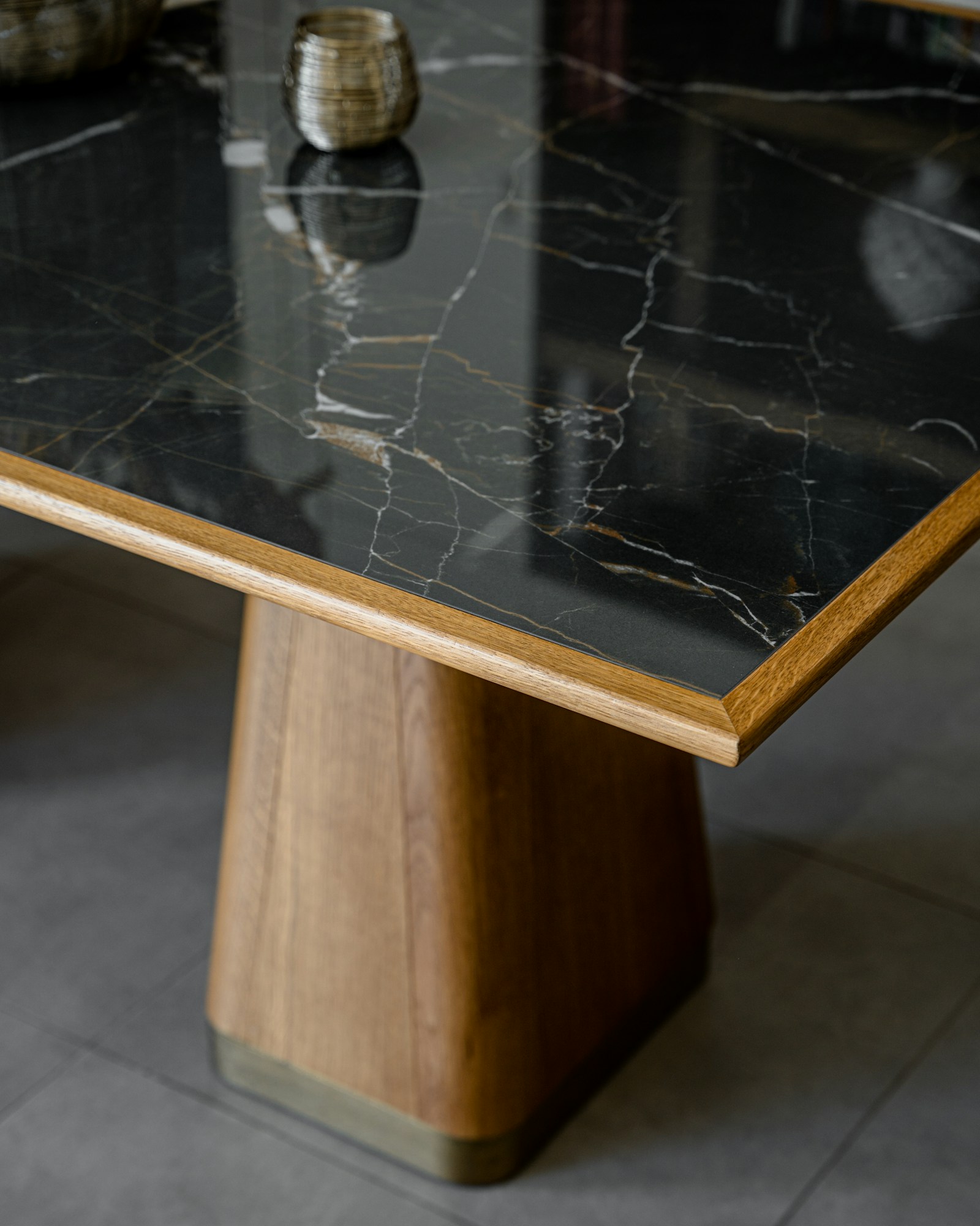 Illustrative reference photograph showing a close-up of a dark marble-top table with a wood base; not NicLogistics inventory.